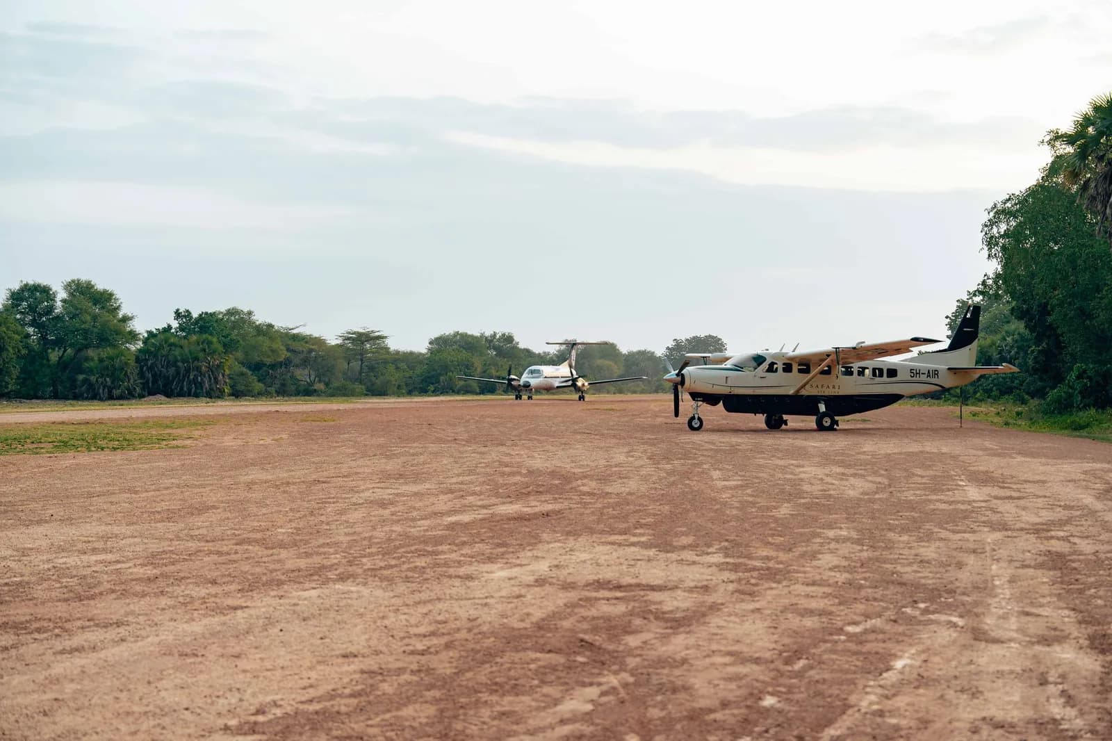 A Cessna Caravan on a dirt airstrip in the Tanzanian bush, the kind of plane that flies from the Serengeti to Zanzibar