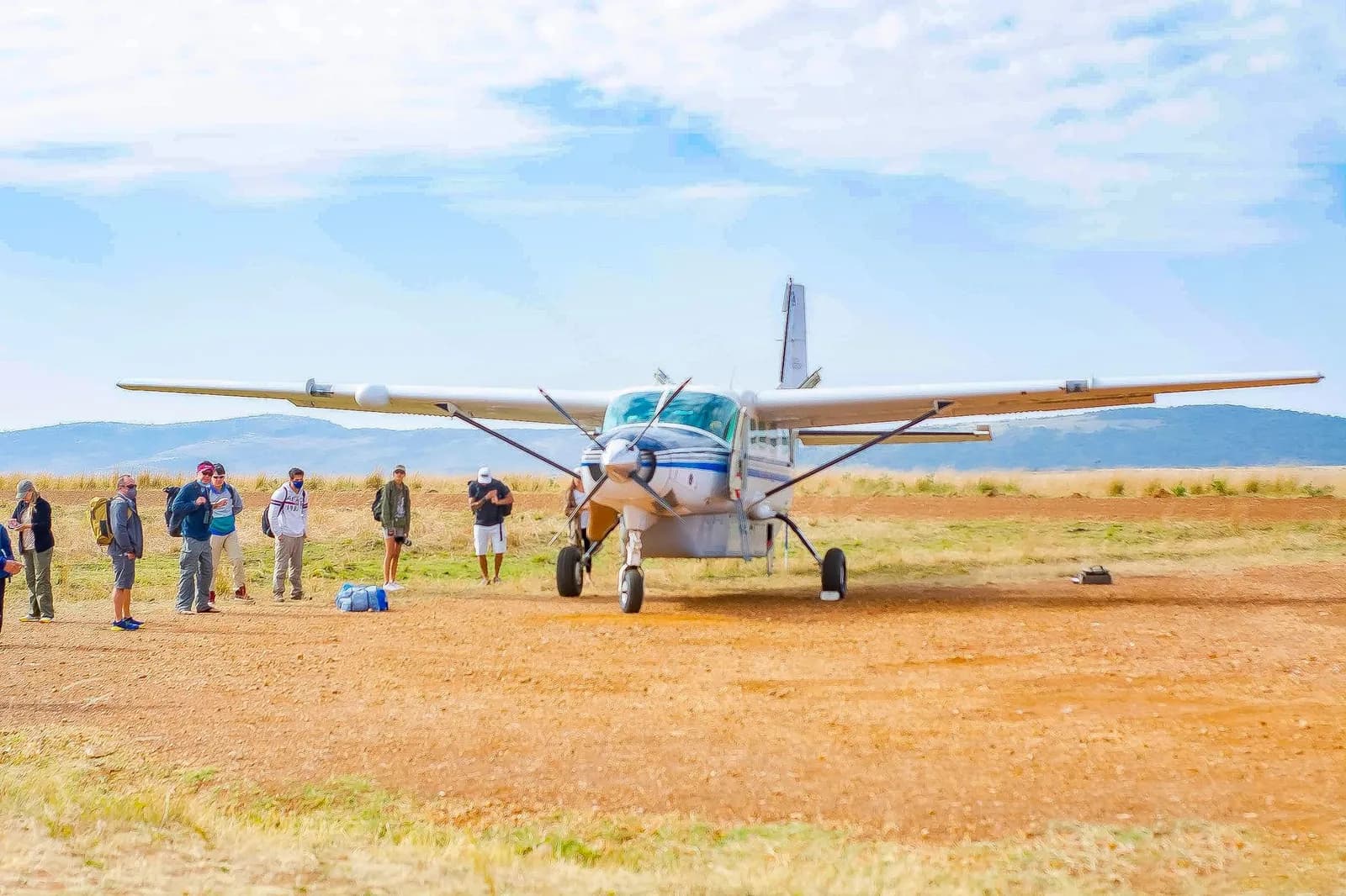 Light aircraft and its passengers on a bush airstrip in East Africa