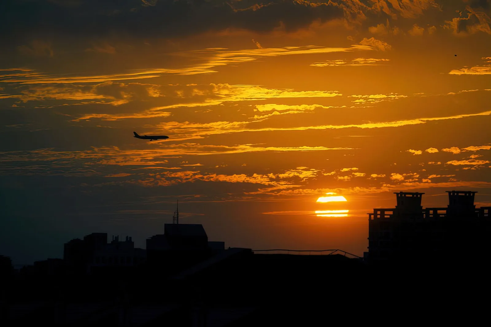 Airliner crossing a golden sky at sunset on the way to Zanzibar
