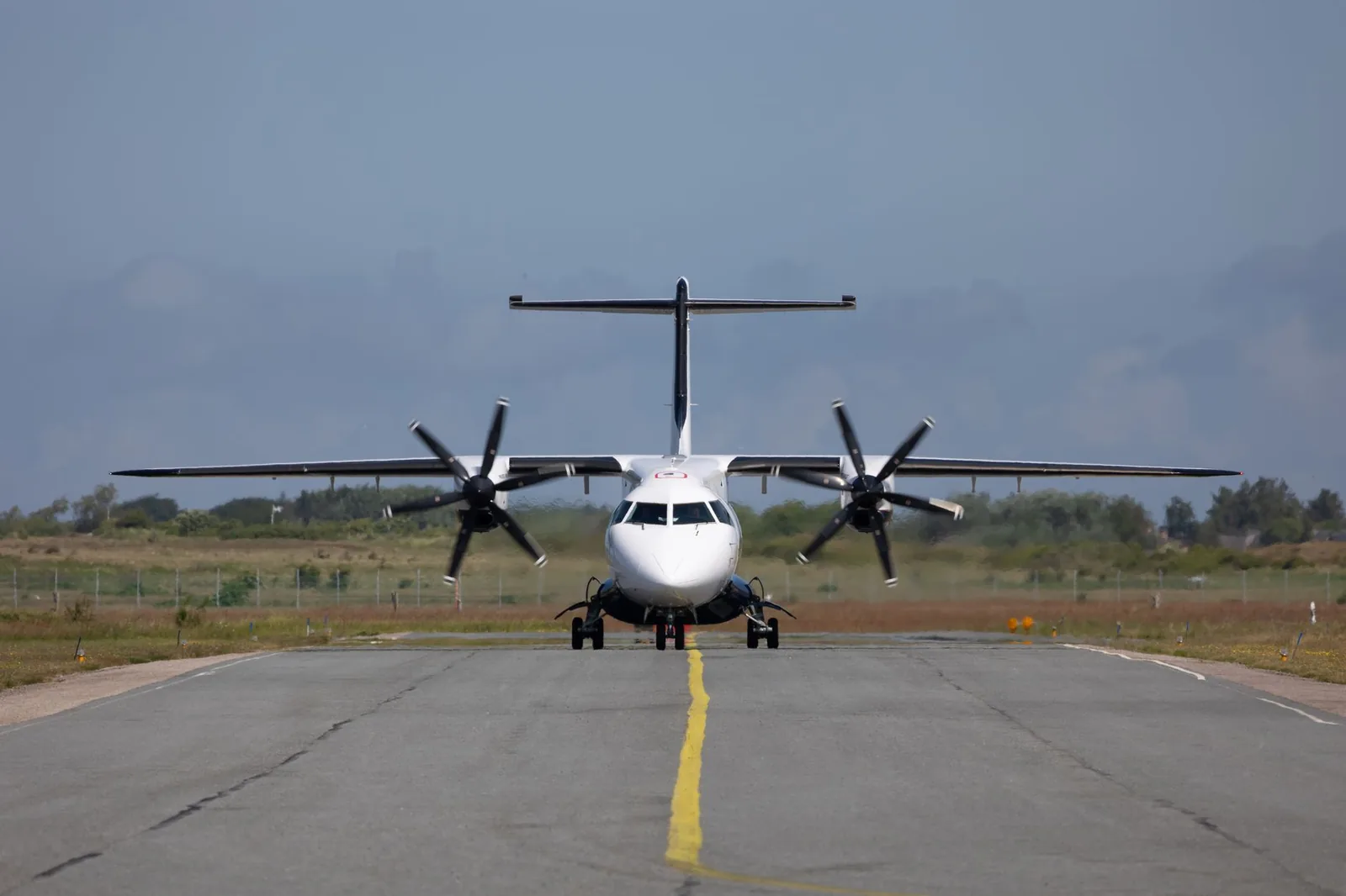 A twin engine turboprop taxiing on an East African runway, the type of plane Precision Air and Flightlink fly from Nairobi to Zanzibar