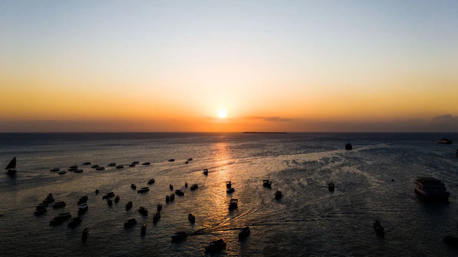 Sunset over the sea off Forodhani, Stone Town, with dozens of boats at anchor