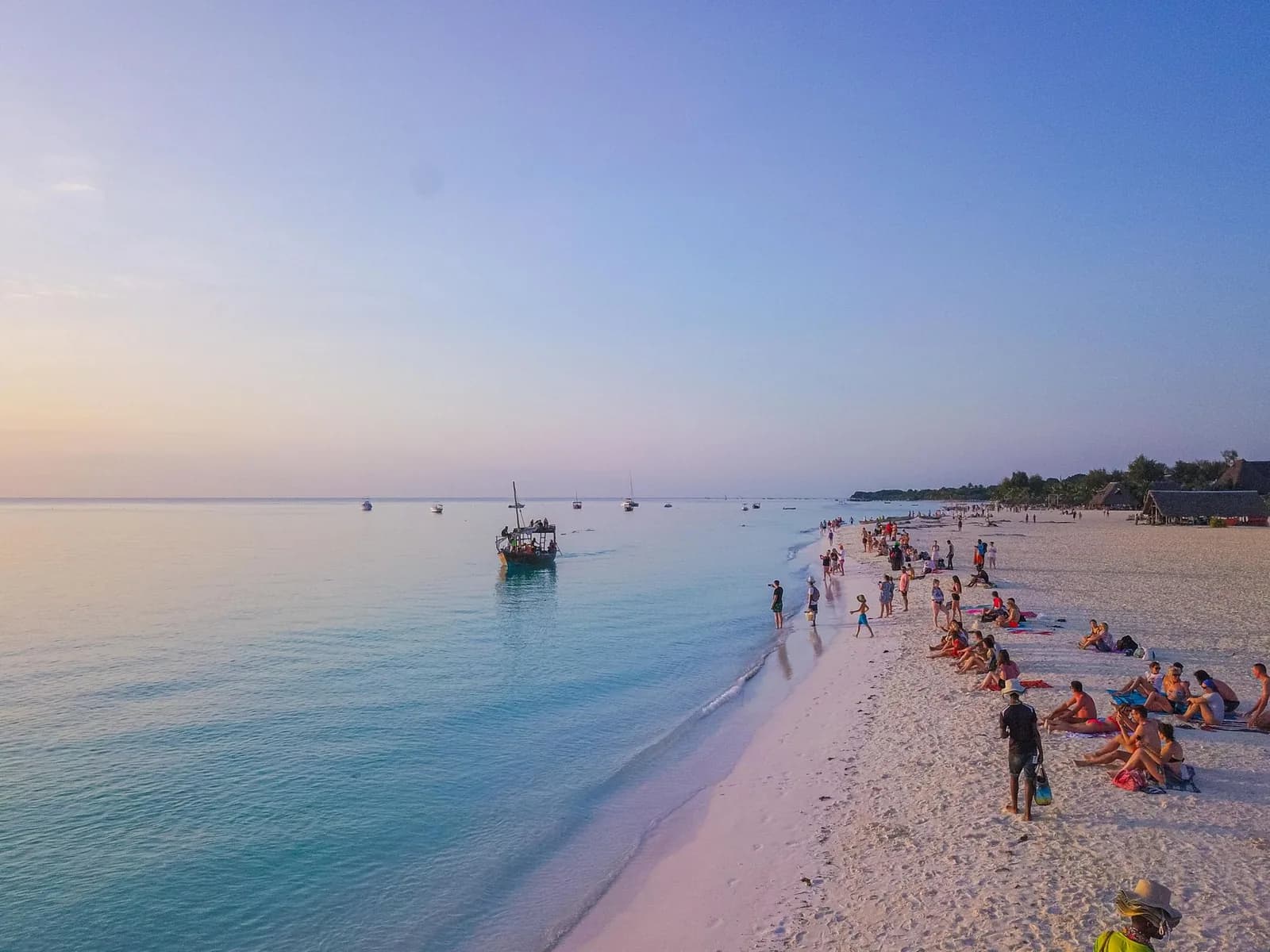 The wide white beach at Kendwa at sunset, with a dhow moored offshore