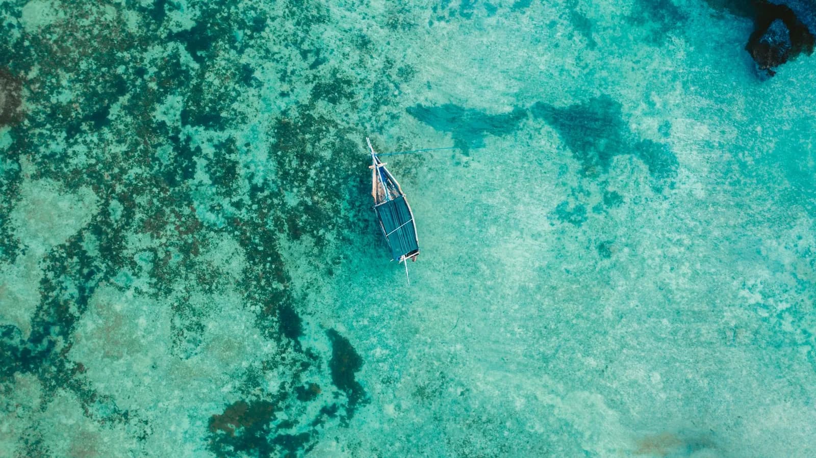 A small boat on turquoise water off the Zanzibar coast