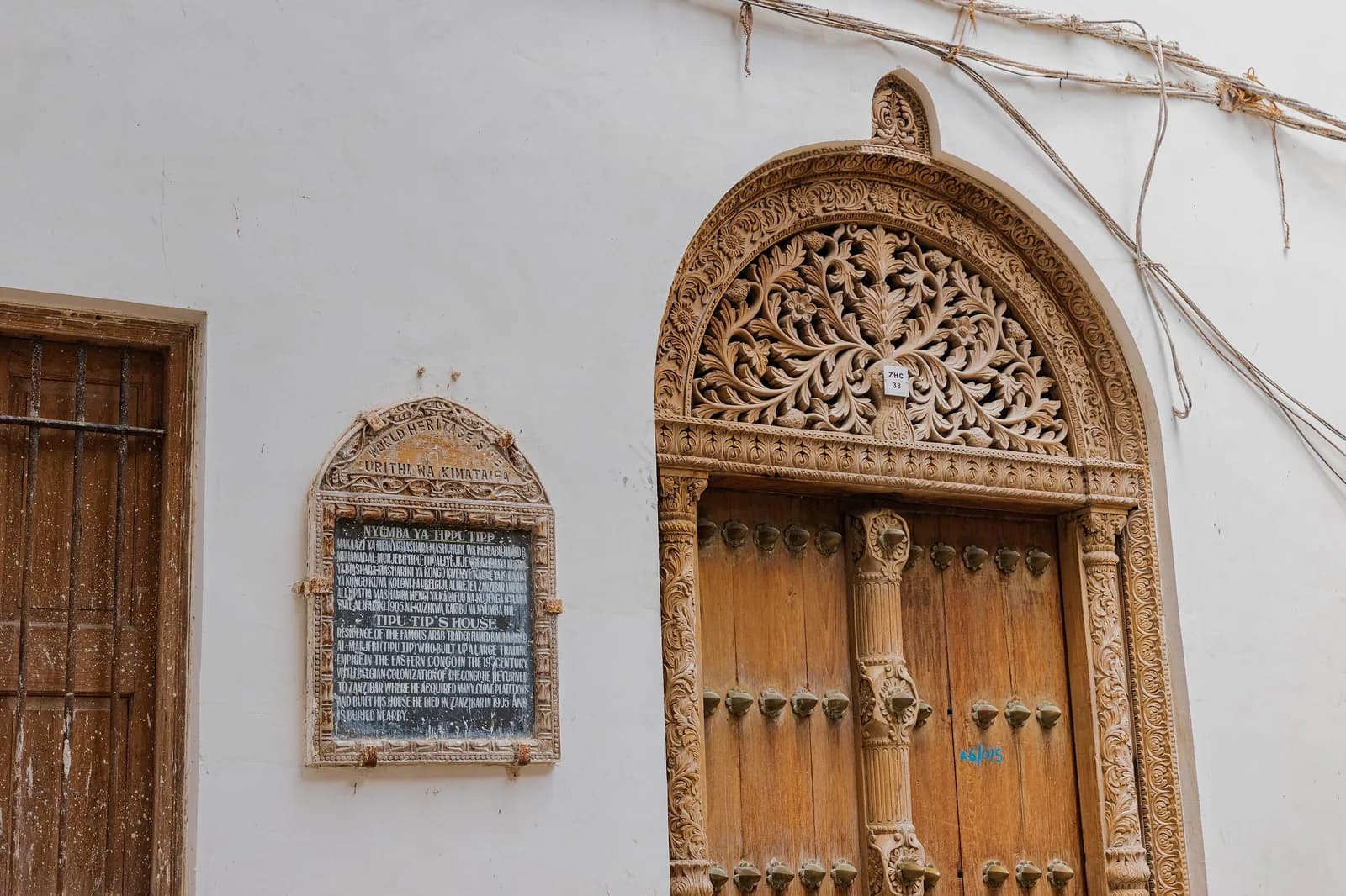 Carved wooden door, marble steps and information plaque of Tippu Tip's House, Shangani, Stone Town