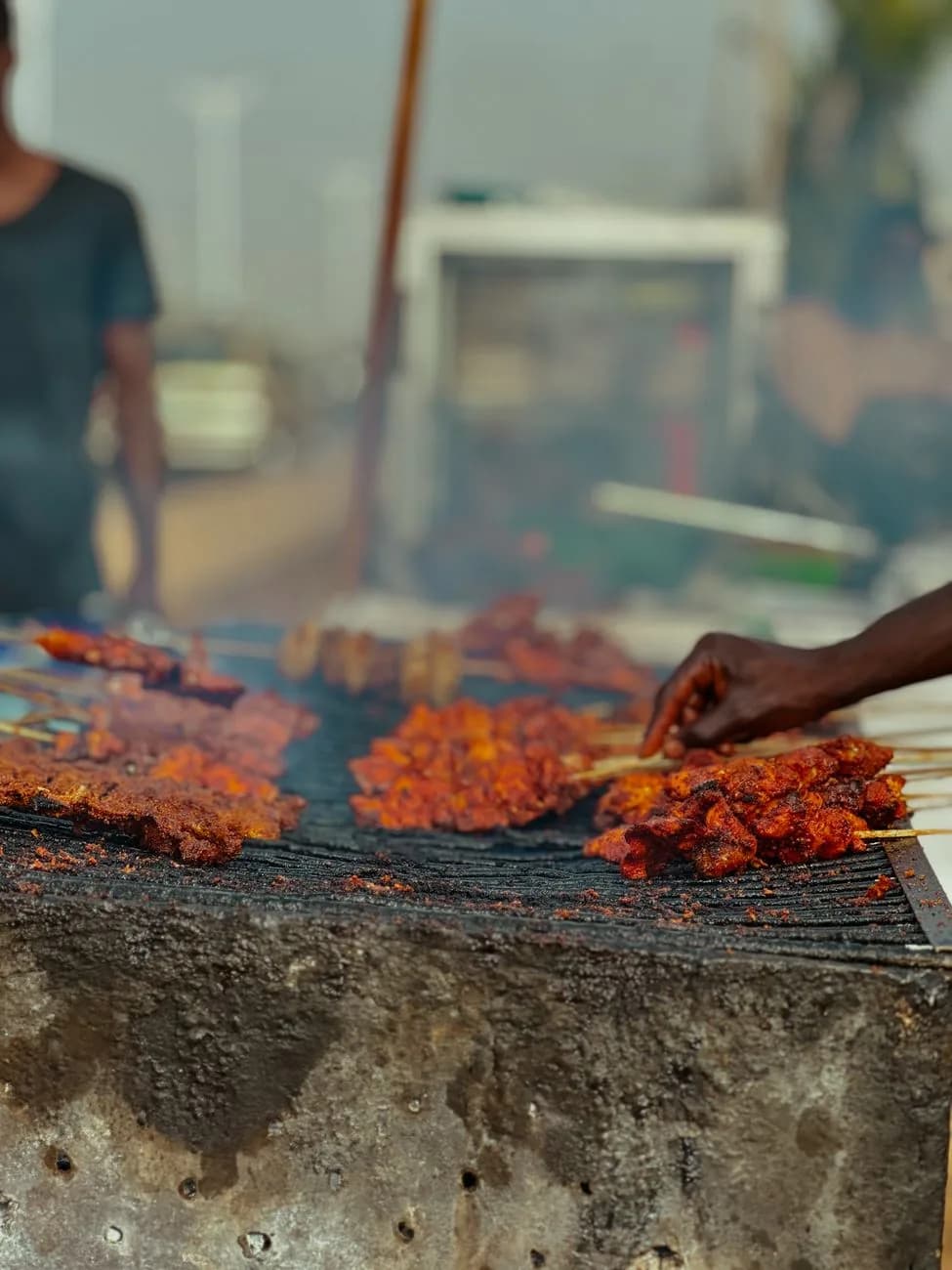 Marinated mishkaki meat skewers grilling over charcoal on a street grill in Zanzibar