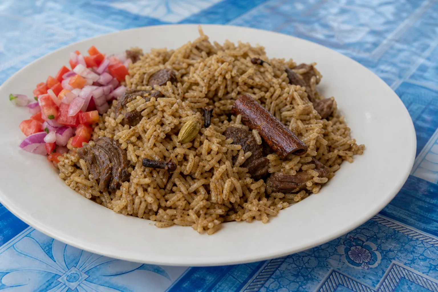 A plate of Zanzibar pilau rice with beef, cinnamon, cardamom and cloves, with kachumbari salad
