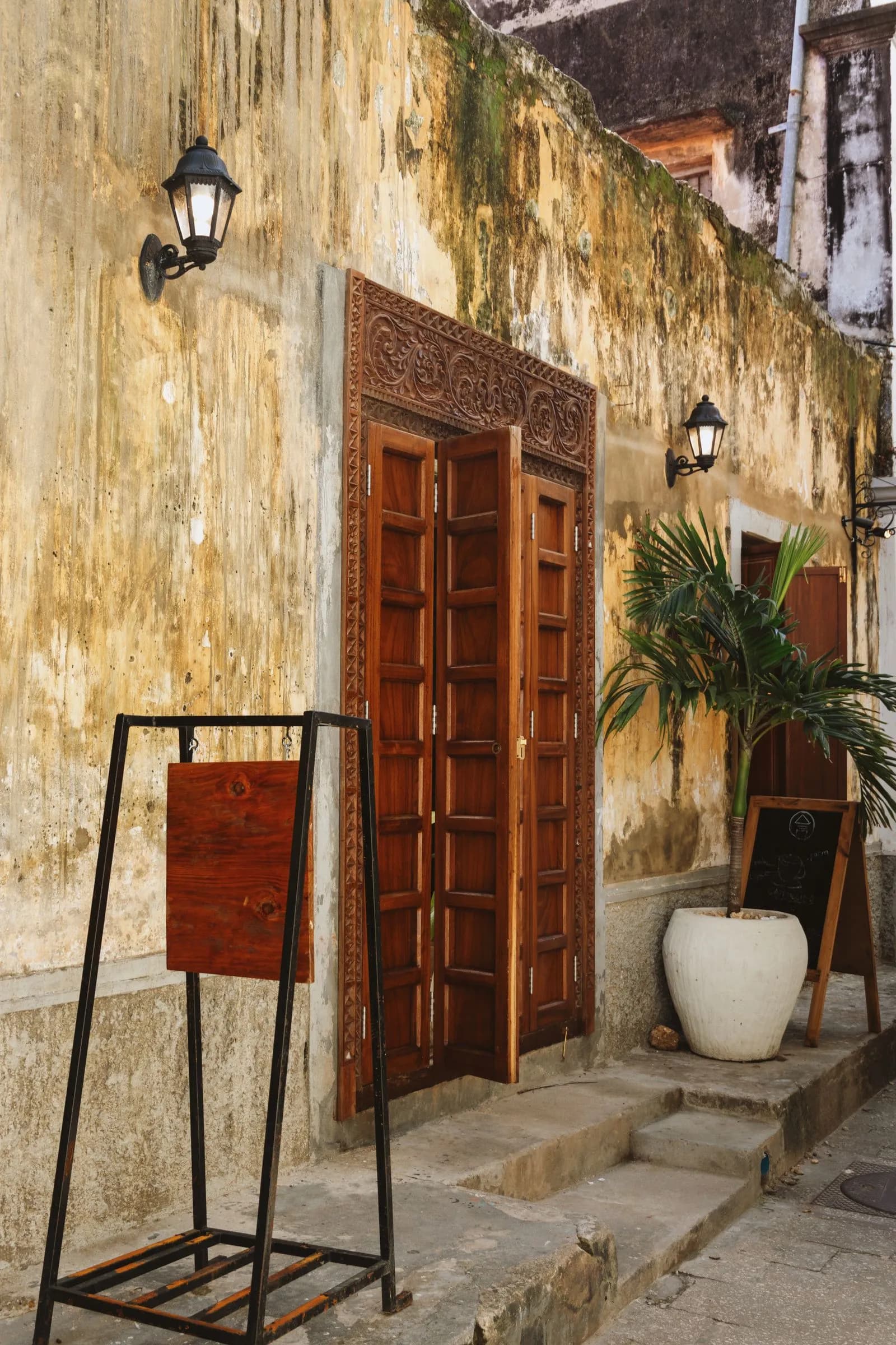 Carved wooden door with an ornate lintel in a lane of Stone Town, Zanzibar