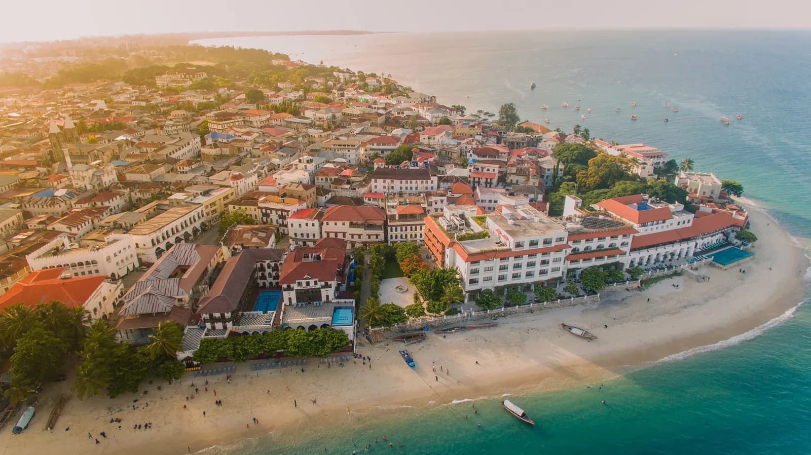Aerial view of the Stone Town waterfront in Zanzibar, with the beach, red-roofed buildings and the lanes of the old town